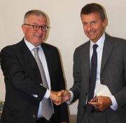 Alberto Cristina (left) and Marco Caleffi (right) shake hands on the acquisition of Cristina by Caleffi, parent company of Altecnic. 