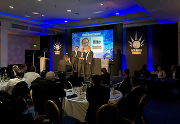 Mike Smith (centre) accepts his award alongside host Marcus Brigstocke (left) and current Bitzer UK managing director, Kevin Glass (right).