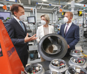 New machines allow for faster and error-free production of modern industrial fans: Chief executive Peter Fenkl shows minister of economic affairs Dr Nicole Hoffmeister-Kraut how high-performance fans for data centres and hospitals are assembled