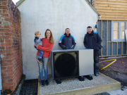 Rachel Salisbury with son Jasper and two of the British Gas engineers that installed their Daikin heat pump - the first in the country to recieve a BUS grant